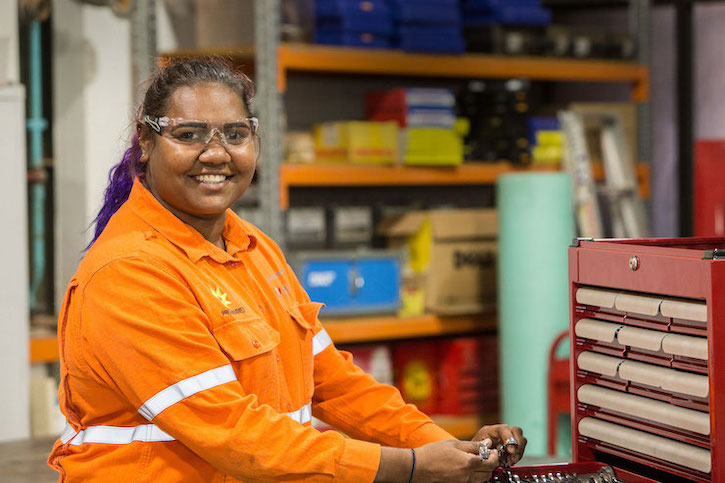 First Nation lady in front of mechanical tools